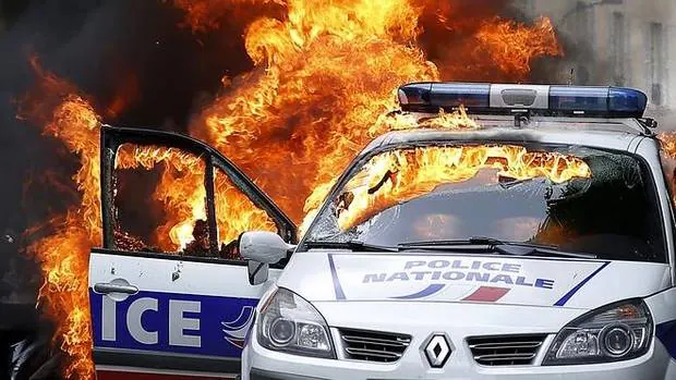 Manifestantes prenden fuego un coche de la policía en París.
