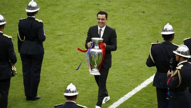 Xavi Hernández entrega el trofeo de ganador de la Eurocopa.