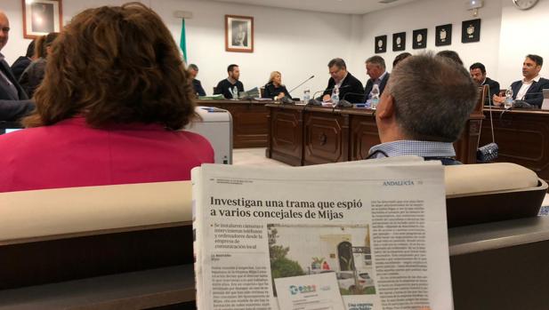Durante el último pleno un asistente leía las revelaciones de ABC sobre el espionaje en Mijas
