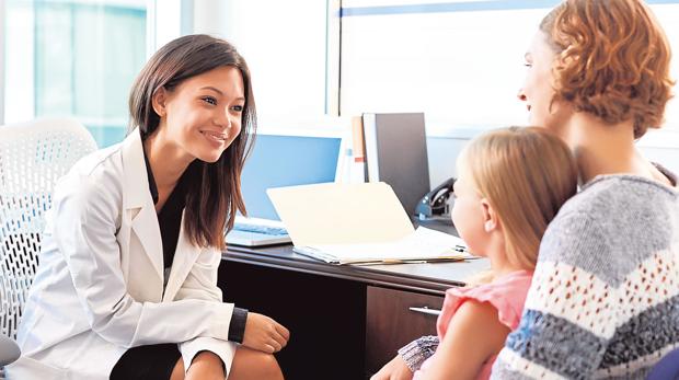 Una doctora atiende a una niña en su consulta