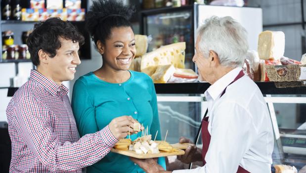 Unos jóvenes degustan unas muestras gratuitas en un supermercado