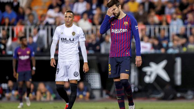 Piqué se lamenta durante un partido ante el Valencia