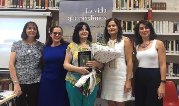 Consolación González Rico, en el centro, con un ramo de flores entregado por la alcaldesa, Elena Fernández, y un libro sobre la historia de Villasequilla