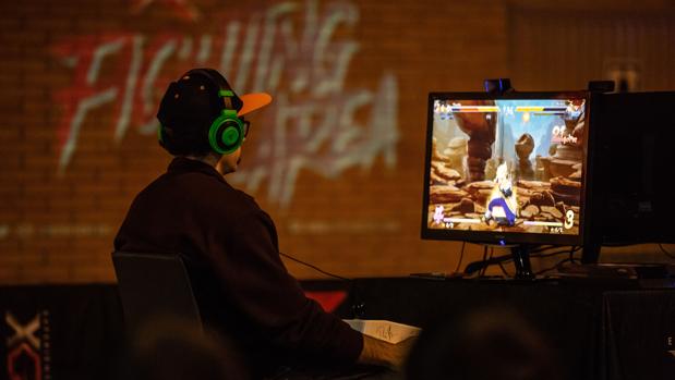 Un joven juega con un videojuego en una feria tecnológica