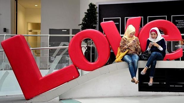 Dos jóvenes musulmanas tuitean en la capital de Indonesia en vísperas de San Valentín