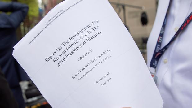Un periodista sostiene una copia impresa de la versión redactada de la declaración del fiscal especial Robert Mueller