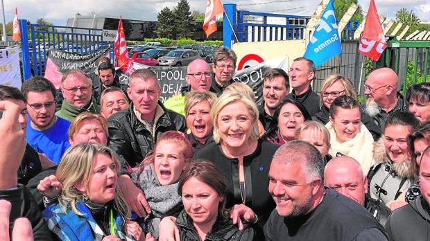 Le Pen con trabajadores de una fábrica en Amiens, en abril de 2017
