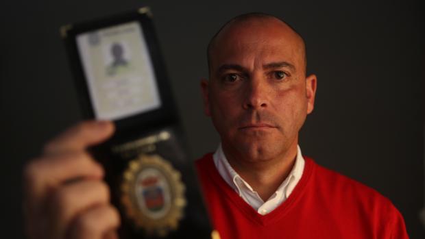 Ernesto Pérez Vera muestra su placa de policía.