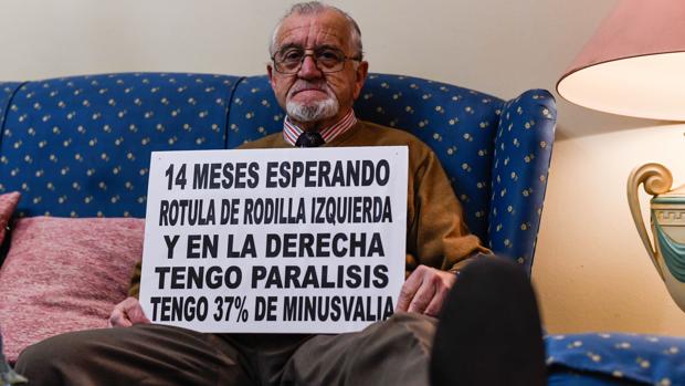 Ricardo Bernal en su casa con un cartel en el que detalla su situación