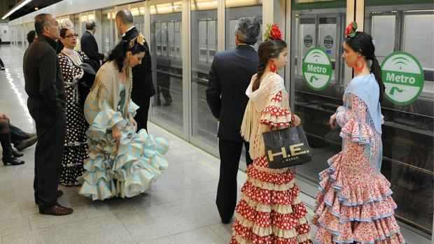 Personas esperando en la parada de metro para ir a la Feria de Abril